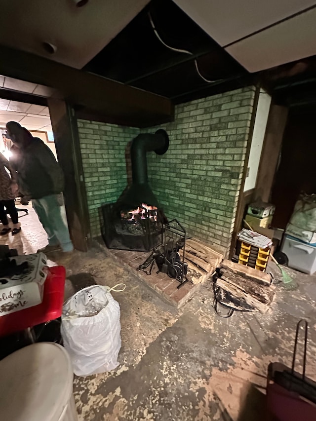 basement with brick wall and a wood stove