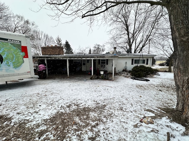 snow covered property with a carport