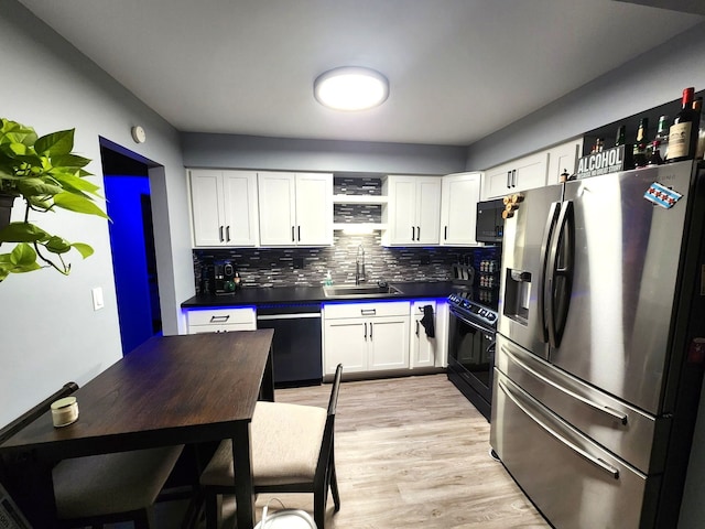 kitchen with backsplash, light wood-type flooring, stainless steel appliances, sink, and white cabinetry