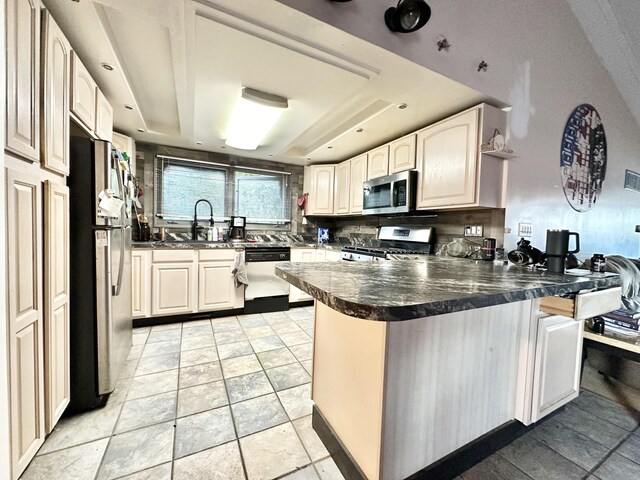 2715 Duck Lake Rd N, Highland, MI 48356 - kitchen with stainless steel appliances, a peninsula, a sink, dark countertops, and stone tile floors