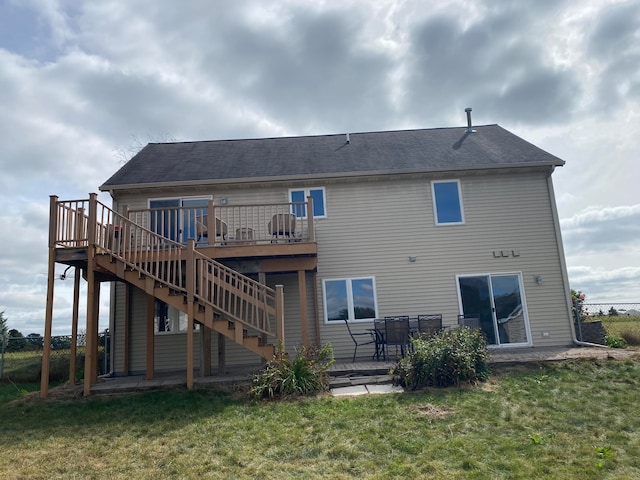 rear view of property with a yard, a deck, and a patio area