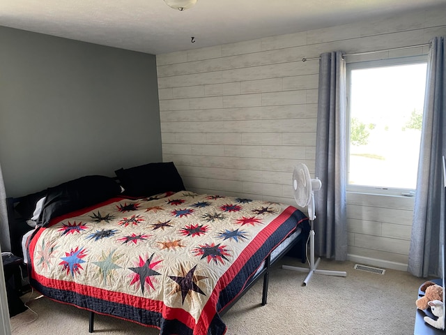 bedroom with carpet and wooden walls