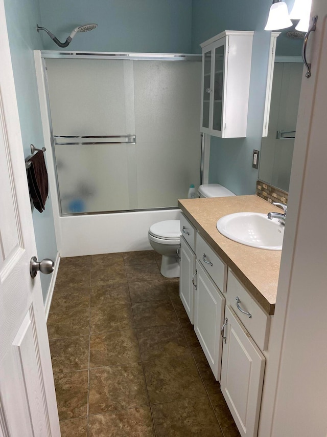 full bathroom with vanity, toilet, and bath / shower combo with glass door