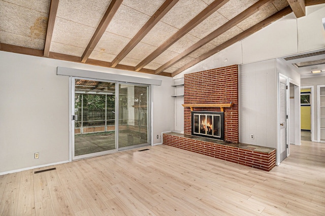 unfurnished living room with beamed ceiling, light wood-type flooring, high vaulted ceiling, and a fireplace