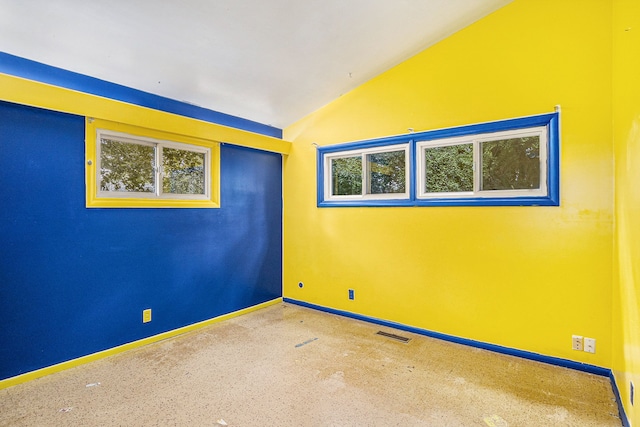 empty room featuring lofted ceiling