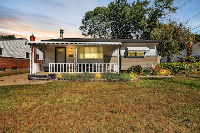 view of front of home with a porch and a yard