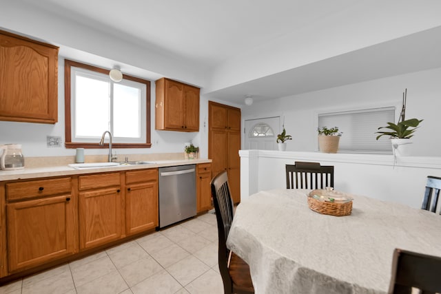 kitchen with light tile patterned flooring, stainless steel dishwasher, and sink