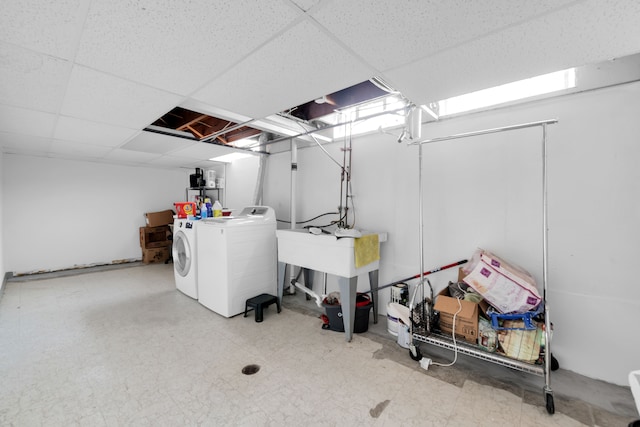 basement with a paneled ceiling and washing machine and dryer