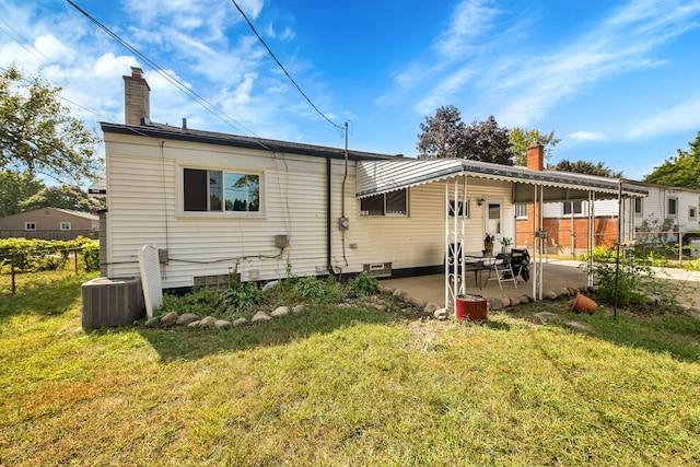 rear view of property with a yard, a patio, and central AC unit