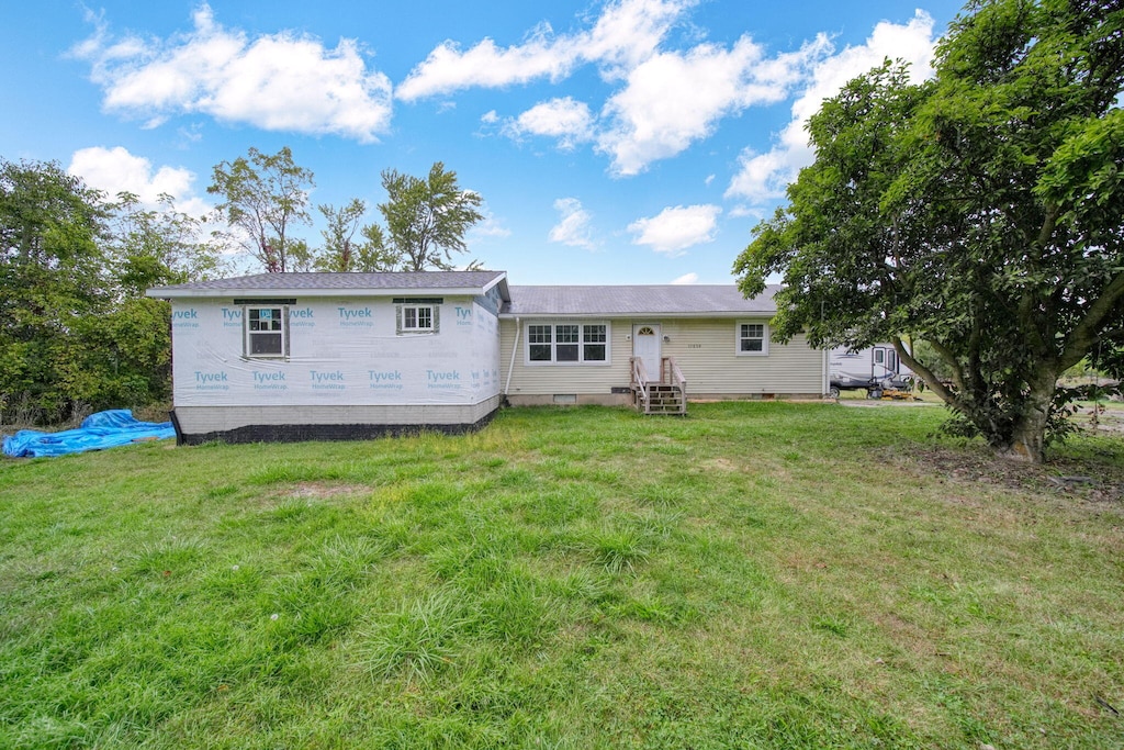 back of property featuring a lawn