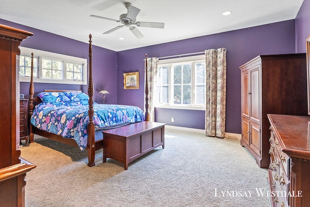 bedroom with multiple windows, ceiling fan, and light carpet