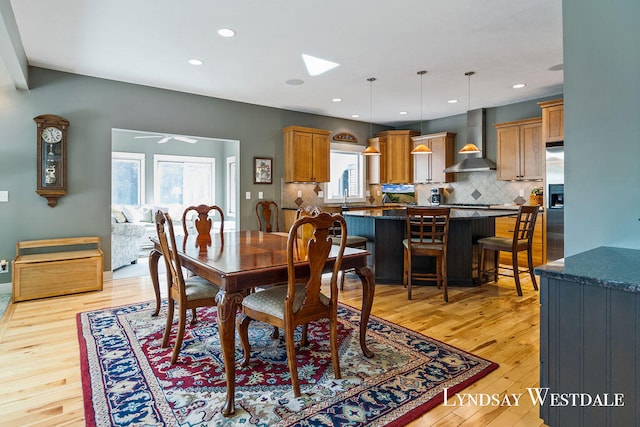 dining room featuring sink, light hardwood / wood-style flooring, plenty of natural light, and ceiling fan