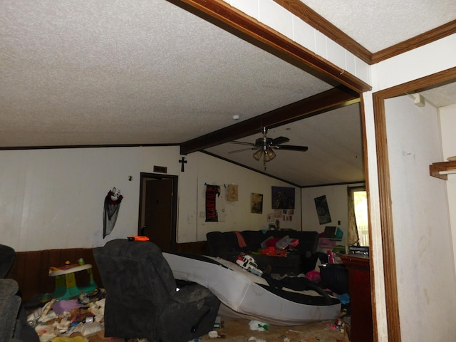 living room featuring a textured ceiling, lofted ceiling with beams, ceiling fan, and ornamental molding