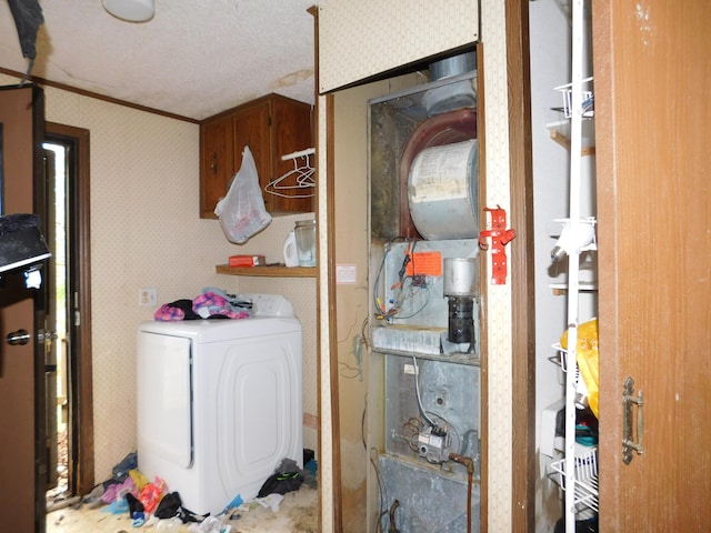 laundry room with a textured ceiling, washer / dryer, and crown molding