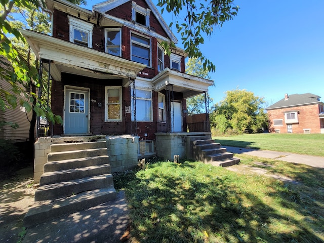 view of front of house with covered porch and a front yard