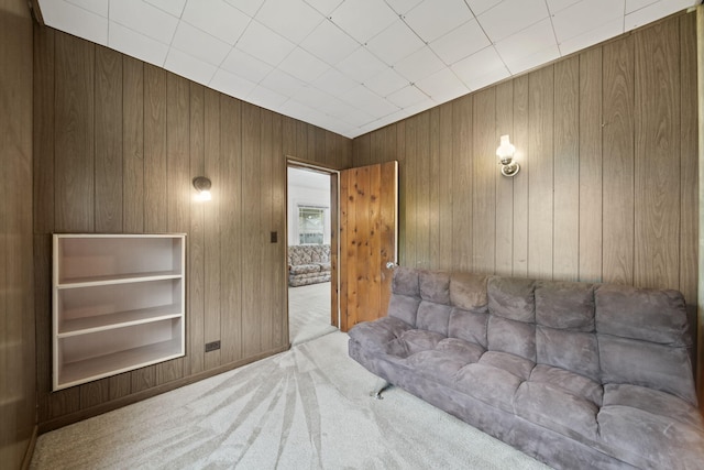 living room featuring light carpet and wooden walls