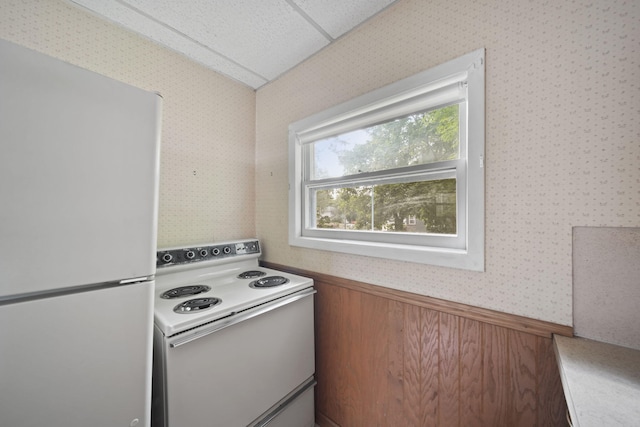 kitchen with a paneled ceiling and white appliances