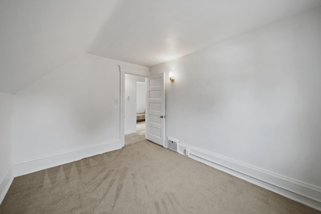 additional living space with light carpet and vaulted ceiling