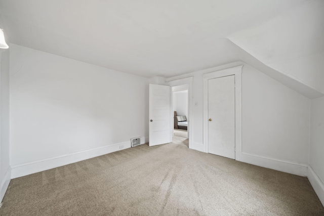 additional living space featuring carpet and lofted ceiling