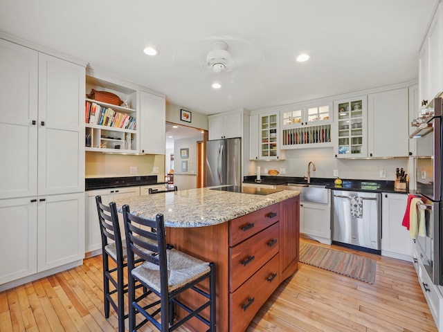 kitchen with a center island, light wood-type flooring, white cabinetry, and stainless steel appliances