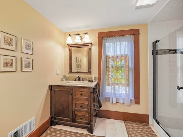 bathroom featuring tile patterned flooring, vanity, and walk in shower