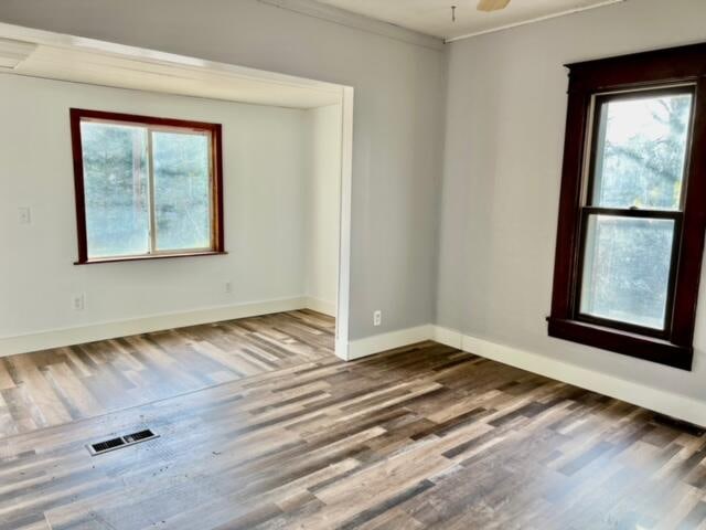 unfurnished room with hardwood / wood-style flooring, ceiling fan, and ornamental molding