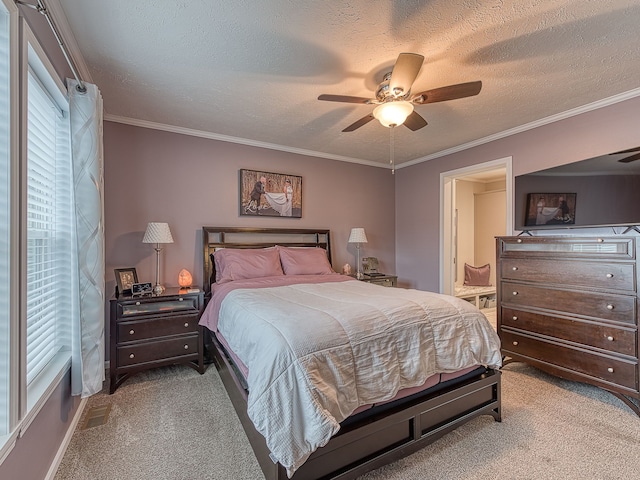 bedroom with a textured ceiling, light colored carpet, ceiling fan, and crown molding