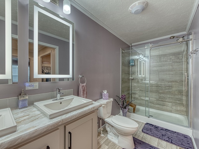 bathroom featuring vanity, hardwood / wood-style flooring, toilet, ornamental molding, and a textured ceiling