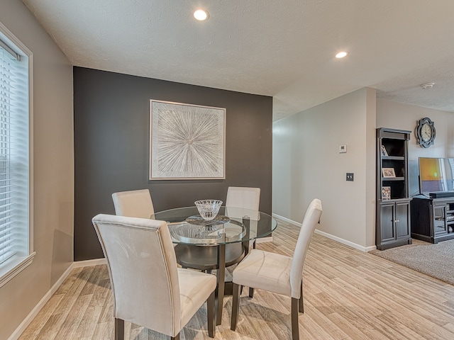 dining room with a textured ceiling and light hardwood / wood-style flooring