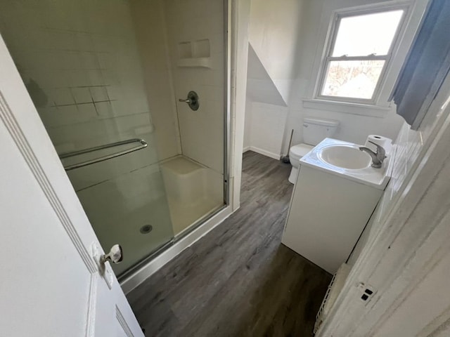 bathroom with hardwood / wood-style flooring, vanity, toilet, and a shower with shower door