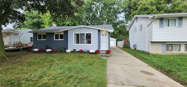 view of front of property with a garage, a front lawn, and an outdoor structure