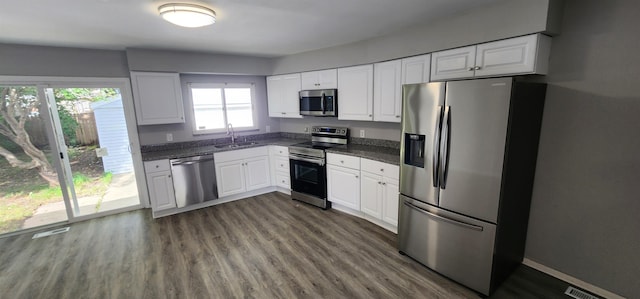 kitchen featuring white cabinets, appliances with stainless steel finishes, dark hardwood / wood-style floors, and sink