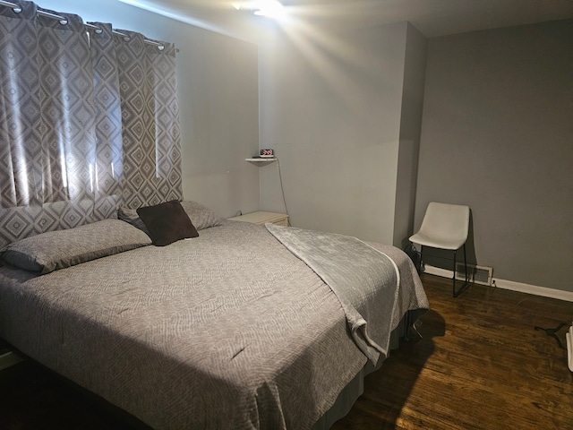 bedroom with dark wood-type flooring