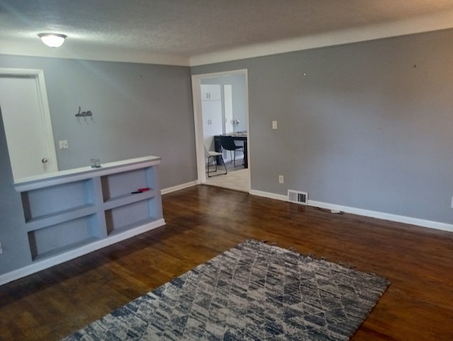 spare room featuring wood-type flooring and a textured ceiling