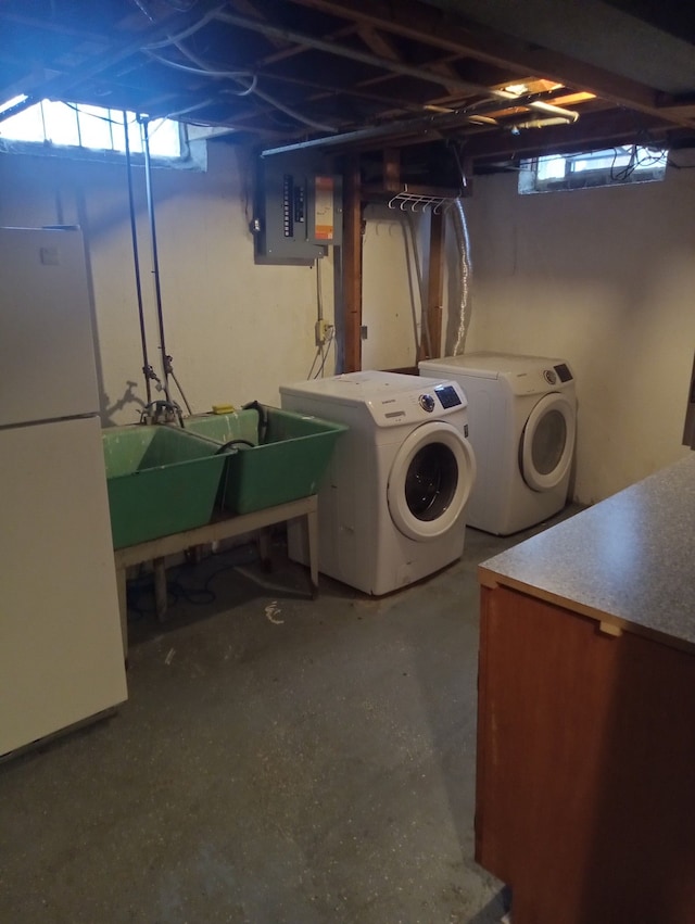 clothes washing area with a healthy amount of sunlight, washing machine and dryer, sink, and electric panel