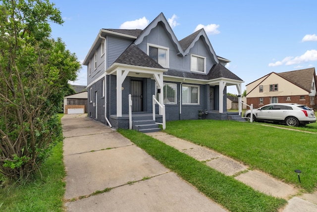 bungalow featuring an outbuilding, a garage, and a front lawn