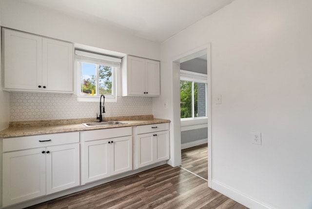 kitchen featuring backsplash, a wealth of natural light, dark wood-type flooring, sink, and white cabinets