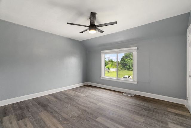 empty room featuring vaulted ceiling, ceiling fan, and dark wood-type flooring