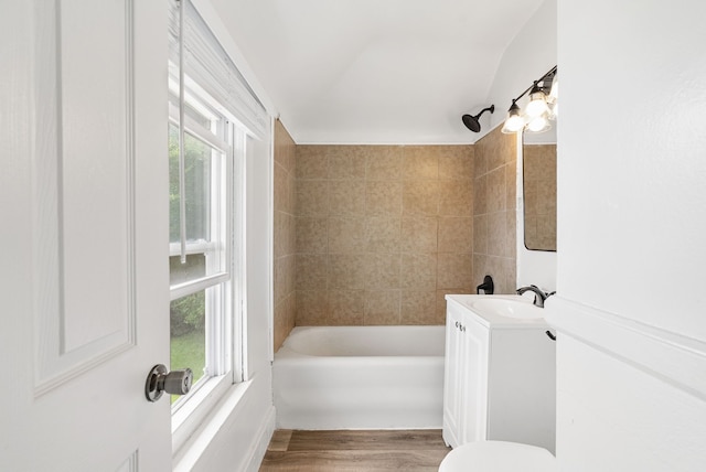 full bathroom featuring tiled shower / bath, vanity, a healthy amount of sunlight, and hardwood / wood-style flooring