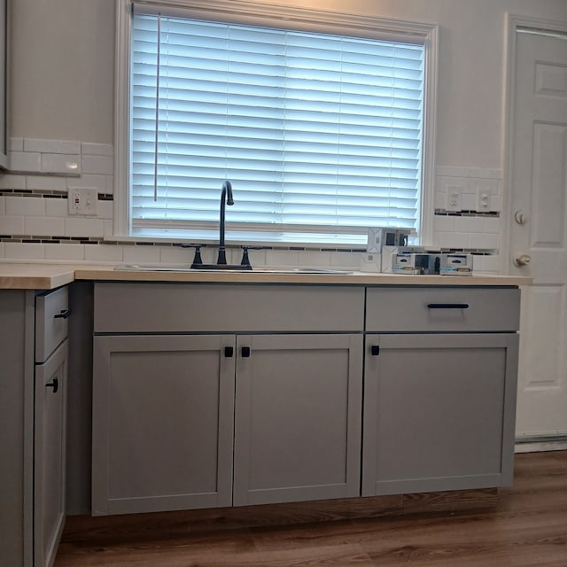 kitchen with dark hardwood / wood-style floors, sink, and tasteful backsplash