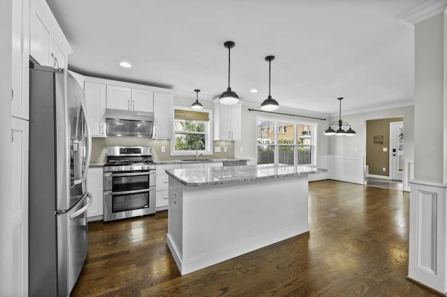 kitchen featuring white cabinets, a center island, sink, and appliances with stainless steel finishes