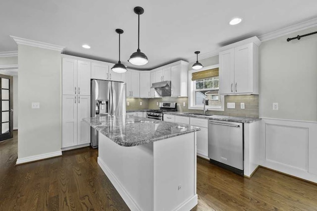 kitchen featuring light stone countertops, stainless steel appliances, a kitchen island, dark hardwood / wood-style floors, and white cabinets