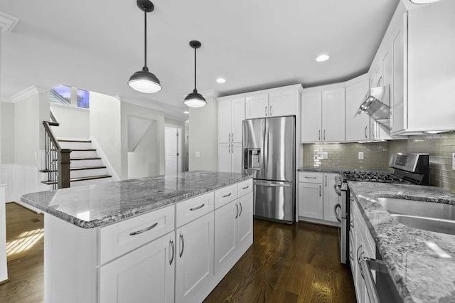 kitchen featuring appliances with stainless steel finishes, a kitchen island, white cabinetry, and dark wood-type flooring