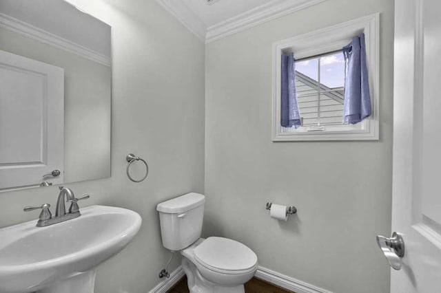 bathroom with crown molding, toilet, and sink