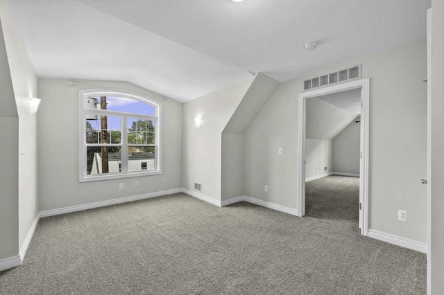 additional living space featuring lofted ceiling and light carpet