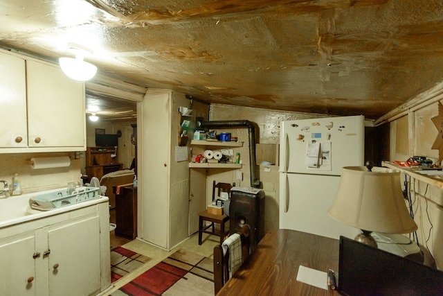 kitchen featuring white cabinets, white fridge, and lofted ceiling