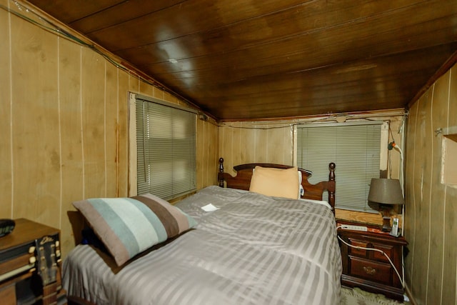 bedroom with lofted ceiling, wood walls, and wooden ceiling