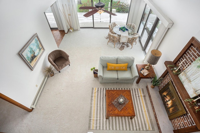 carpeted living room with ceiling fan and a baseboard radiator