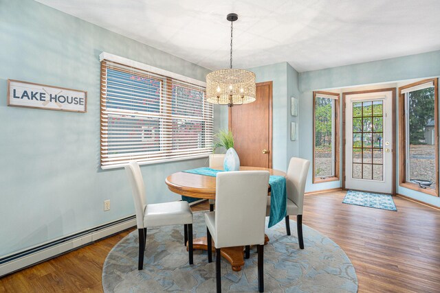 1875 Edwin Dr, Wayland, MI 49348 - dining room featuring a baseboard heating unit, a chandelier, wood finished floors, and baseboards