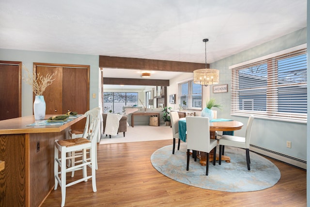1875 Edwin Dr, Wayland, MI 49348 - dining space with baseboard heating, wood finished floors, and a chandelier